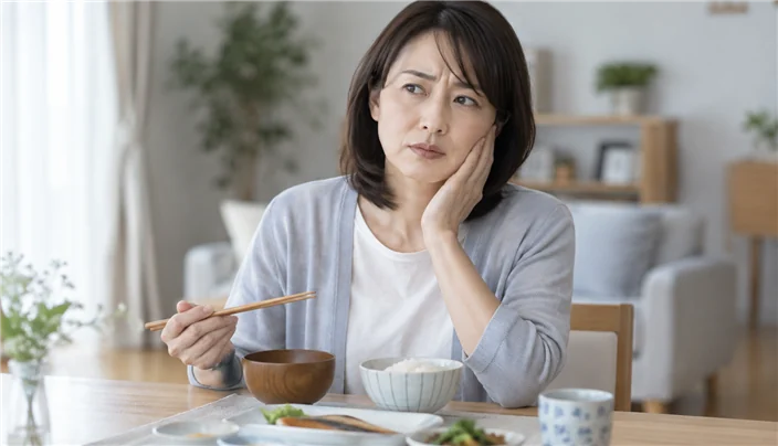 食事中に奥歯で噛みにくさを感じている女性