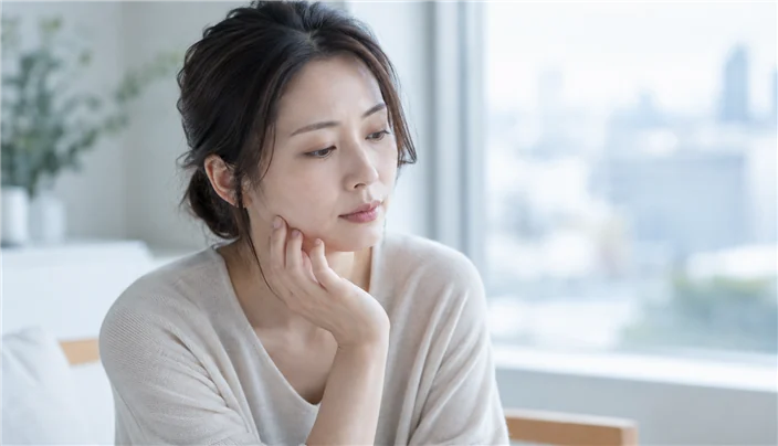噛み合わせが気になり考えこむ女性